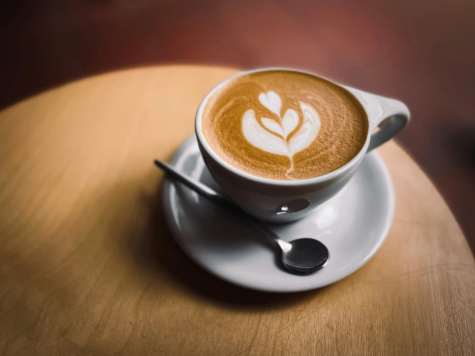 A cup of coffee with latte art on a saucer